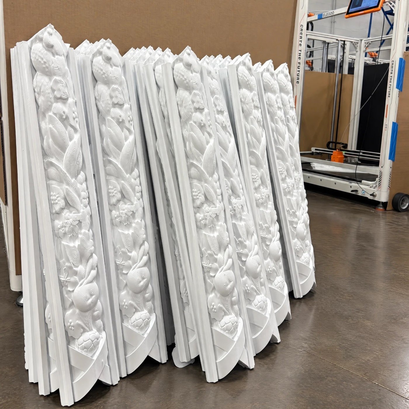 Stacks of molding sections beside the large printer