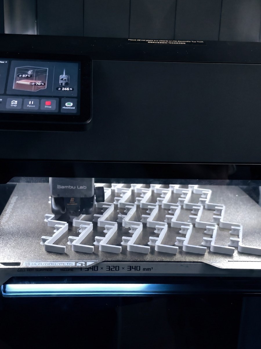 A build plate full of store-fixture pins in the printer