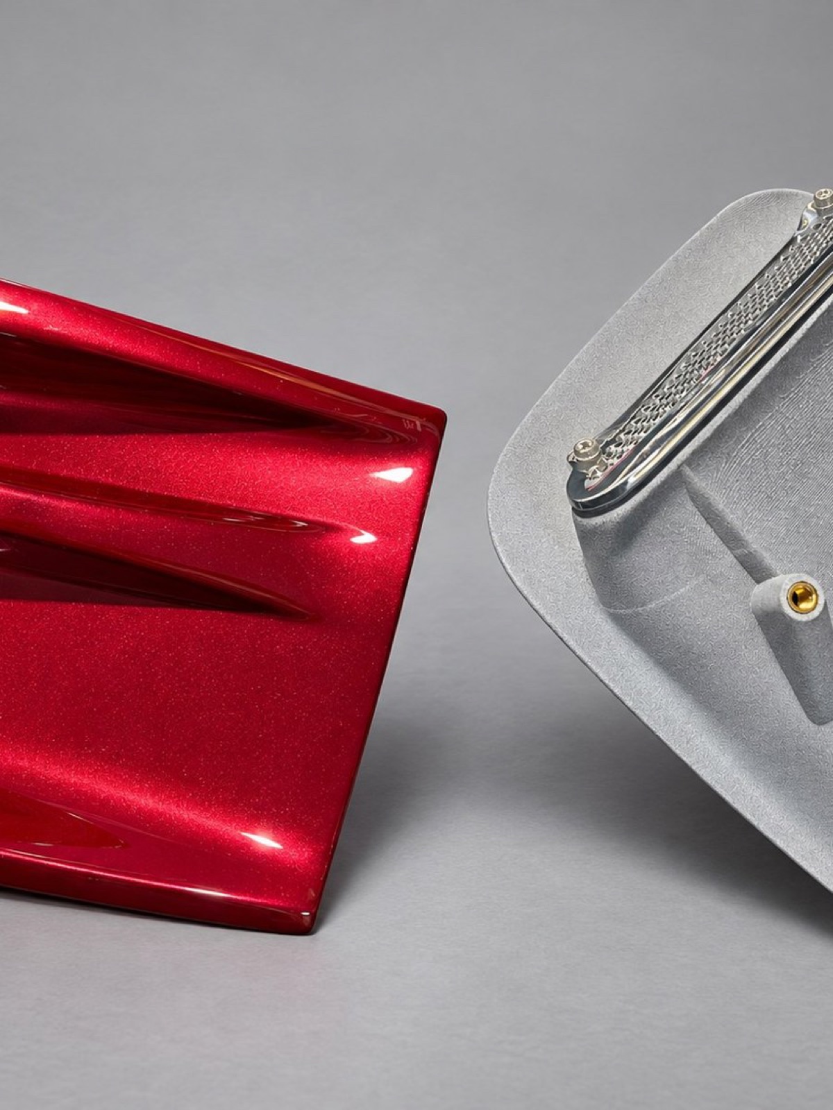 Glossy red side-scoop air duct beside its matching grey nylon back plate