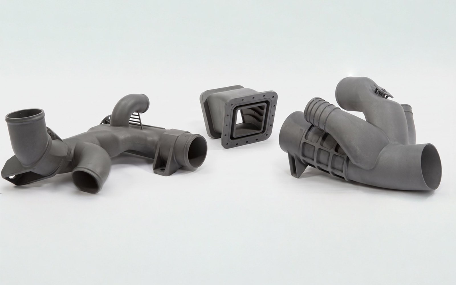 Grey nylon manifolds with enclosed curved passages and branching outlets