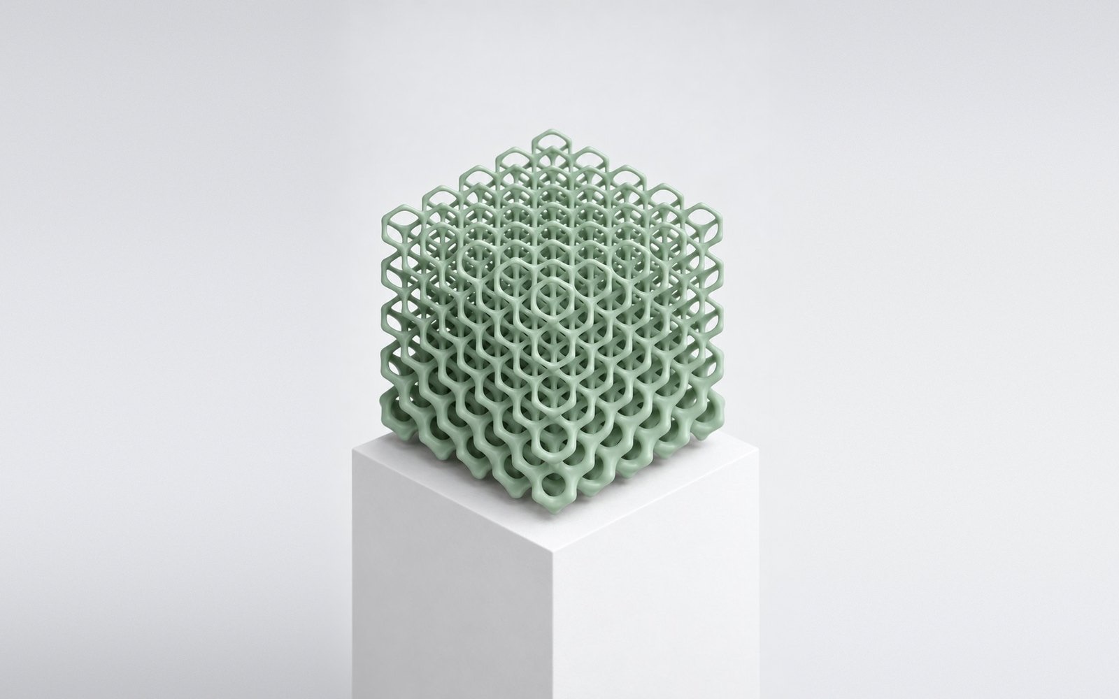 Green lattice cube on a white plinth