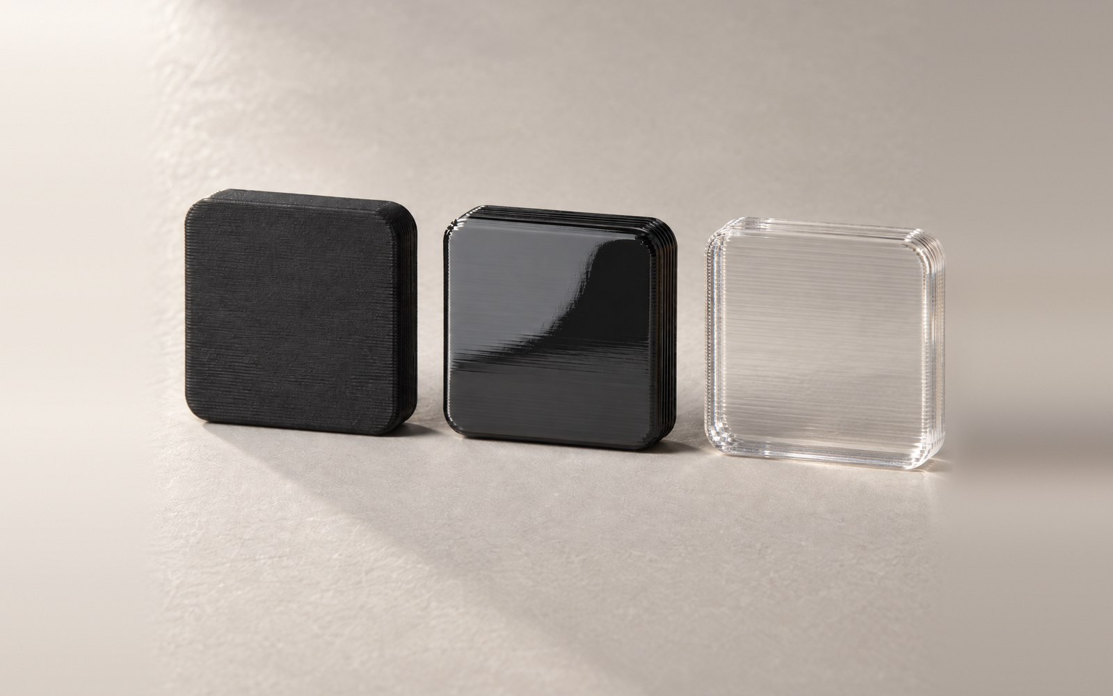 Three printed sample tiles: matte black, glossy black and clear
