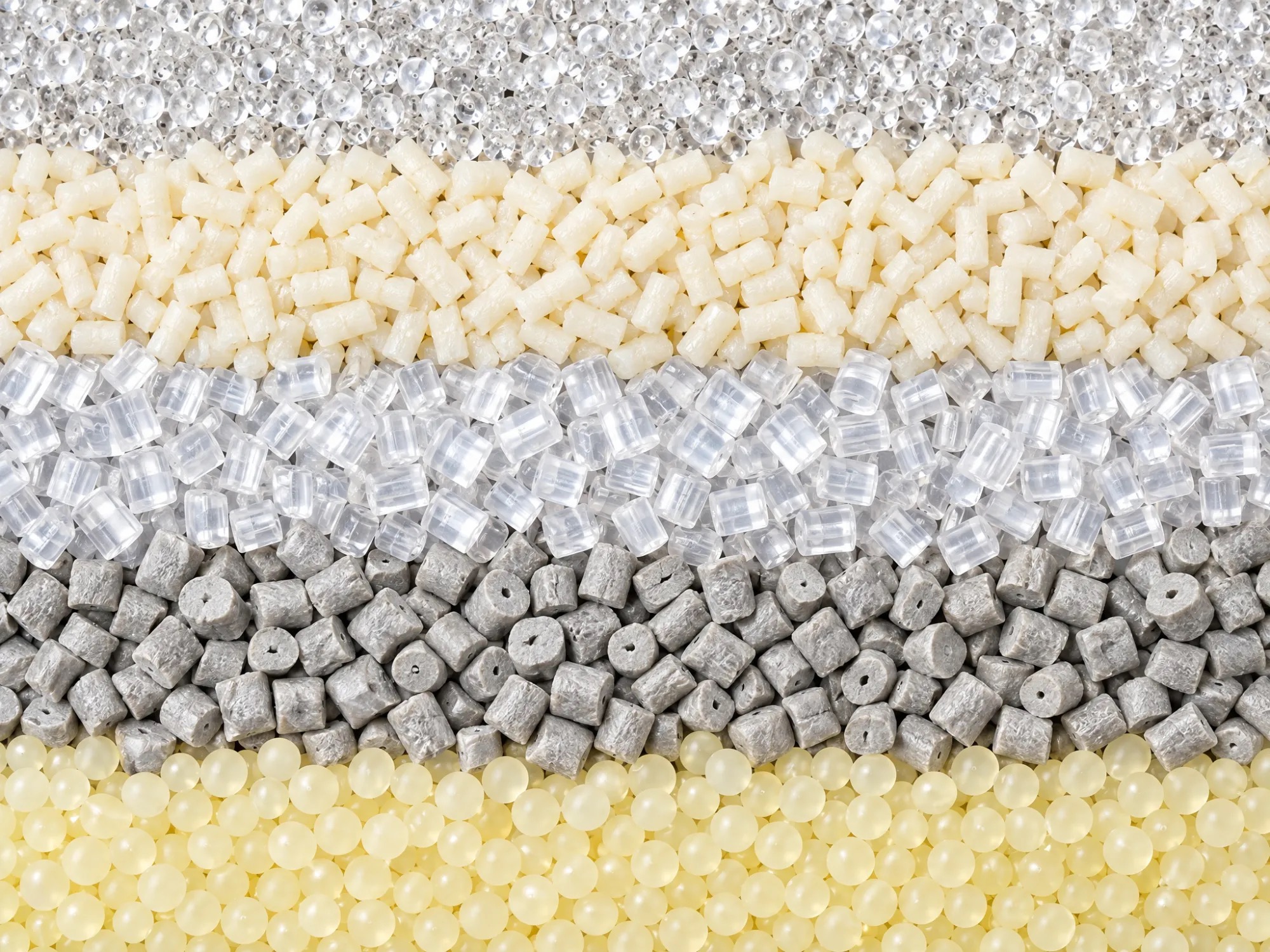 Rows of plastic pellets in clear, natural, grey and amber