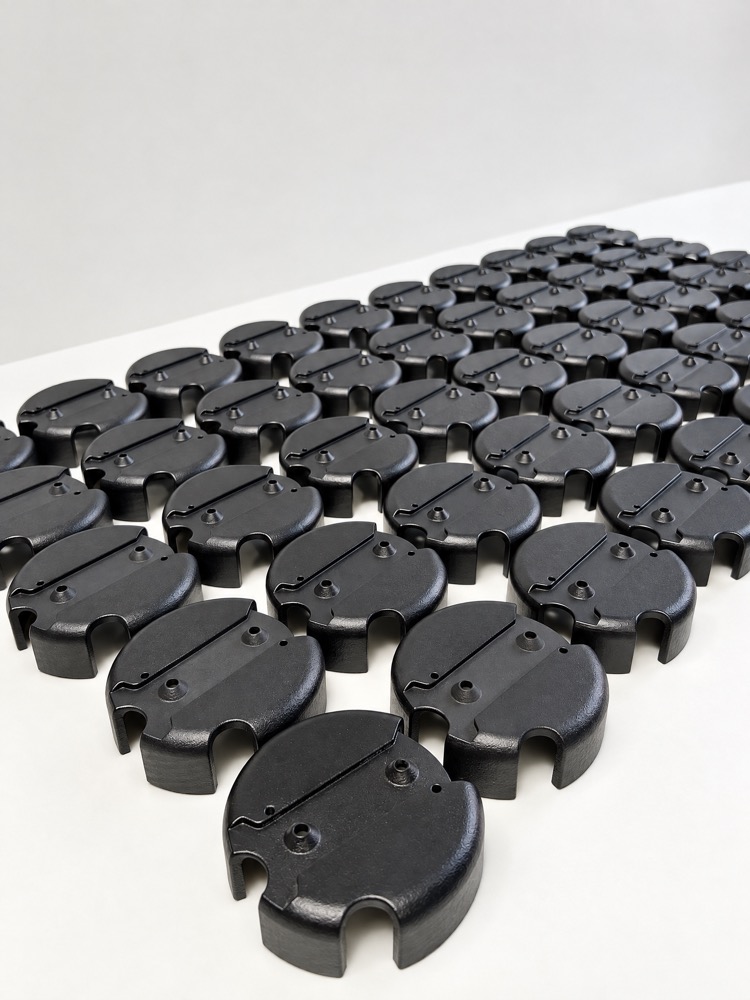 Rows of identical black printed enclosure caps